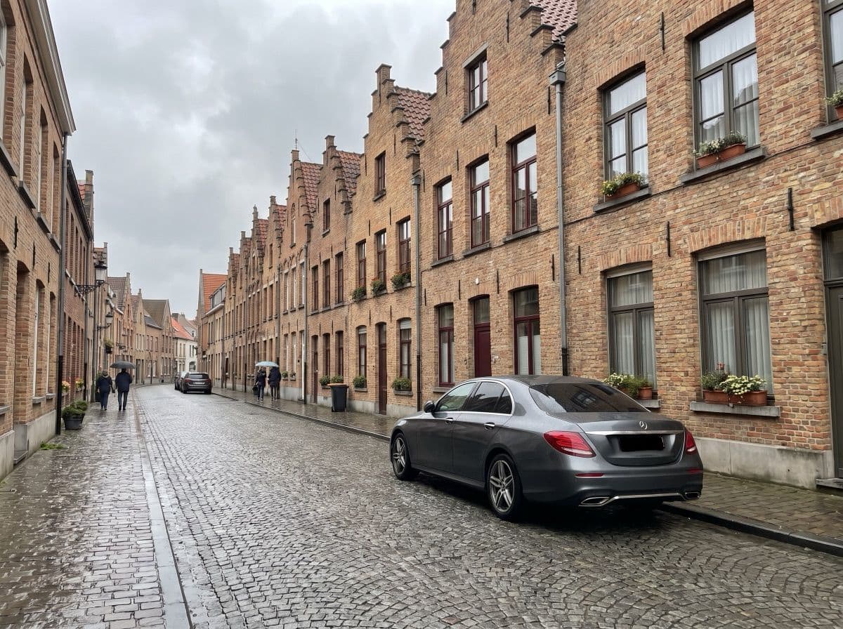 Auto geparkeerd in een Belgische straat met trapgevels